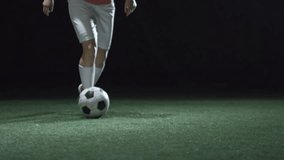 Low section of female soccer athlete’s legs practicing dribbling in a dark stadium, highlighting sports, training, and athletic movement. - Powered by Shutterstock - Get 15% off with code: PIKWIZARD15