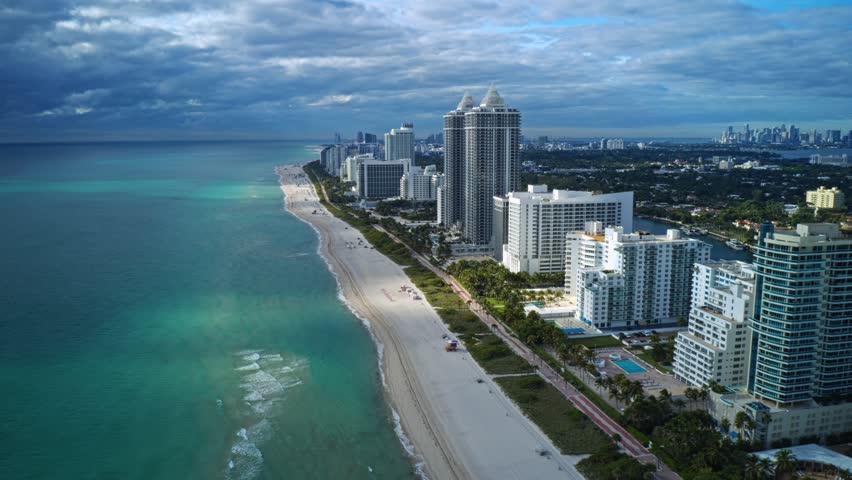 Oceanfront towers rise above the wide sandy shoreline of North Beach as turquoise Atlantic water meets Miami’s distant skyline, creating a dynamic coastal corridor along Florida’s southeast coast.