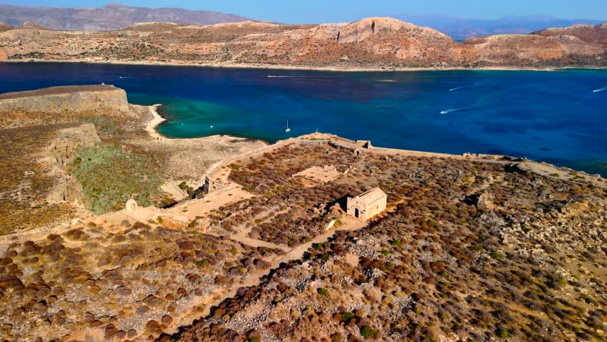 Discover the stunning landscape of Crete featuring ancient ruins beside a beautiful coastline at sunset. Experience the captivating blend of history and nature in this serene location.