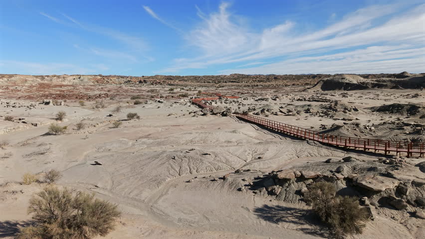 Valle de la Luna, Parque Provincial Ischigualasto, Argentina, showcasing a vast arid landscape with unique geological formations and a long wooden boardwalk for exploration