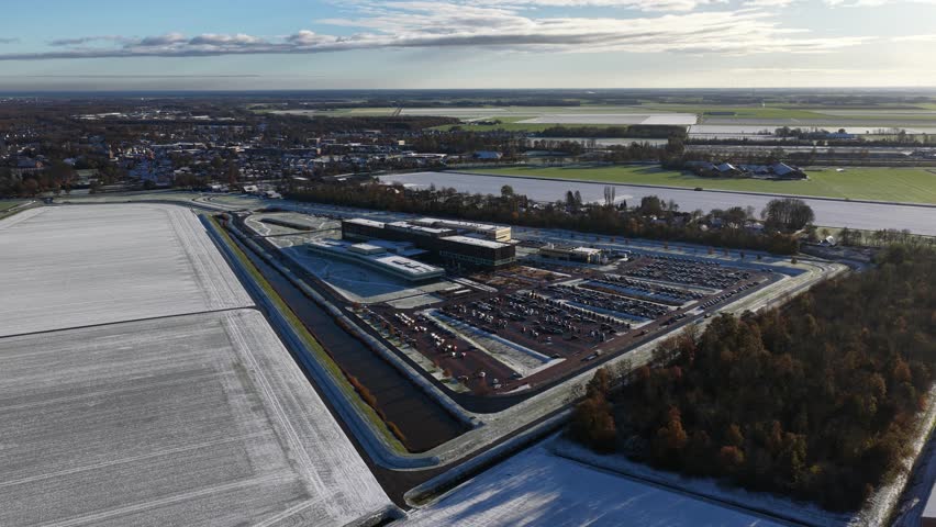 Aerial drone video footage of the modern Ommelander Hospital in Scheemda, Groningen, in a winter landscape. The facility is a sustainable, energy-efficient, and welcoming healthcare building.