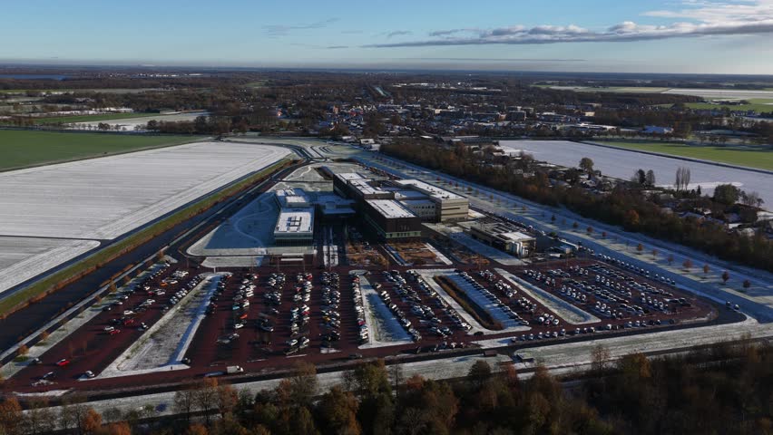 Aerial drone video footage of the modern Ommelander Hospital in Scheemda, Groningen, in a winter landscape. The facility is a sustainable, energy-efficient, and welcoming healthcare building.