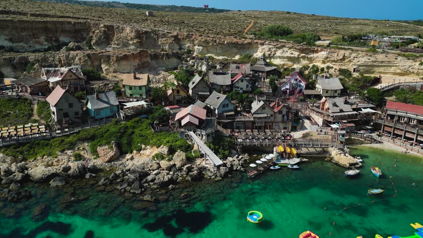 Aerial view of Popeye Village, Malta. Colorful seaside cottages, turquoise waters