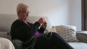 Senior woman enjoying her knitting hobby while her adult daughter sits beside her, engrossed in her smartphone. Mother and daughter sharing a moment - Powered by Shutterstock - Get 15% off with code: PIKWIZARD15