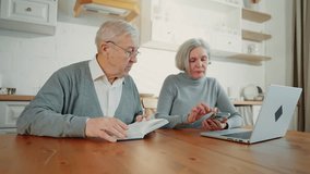 Old spouses discussing leisure and passions, man read book and woman use gadgets . Diversity and unity in relationship, senior wife and husband spending weekend at home, sitting together in kitchen - Powered by Shutterstock - Get 15% off with code: PIKWIZARD15