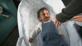 Happy adorable newborn baby lies in a cozy bassinet reaching toward an adult hand while smiling warmly creating a tender home moment with soft natural light and a calm relaxed atmosphere - Powered by Shutterstock - Get 15% off with code: PIKWIZARD15