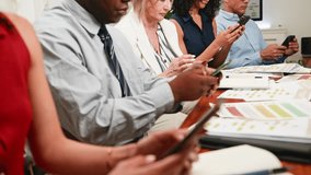 Diverse Business Professionals Engaged with Smartphones During a Corporate Meeting - Powered by Shutterstock - Get 15% off with code: PIKWIZARD15