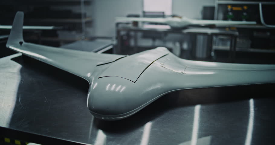 Production Line Displaying Finished Defense Unmanned Vehicles. Industrial Wide Shot of Several Finished Defense Unmanned Vehicles Ready For Inspection. Scale and Organization of High Tech Factory.