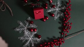 A festive Christmas greeting card on a dark green background surrounded by red ornaments and decorative frosted branches, creating a warm holiday atmosphere. - Powered by Shutterstock - Get 15% off with code: PIKWIZARD15