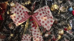 footage of a beautifully decorated Christmas tree, focusing on a large, rustic-style bow. The tree is warmly illuminated by twinkling fairy lights, creating a cozy and inviting holiday atmosphere. - Powered by Shutterstock - Get 15% off with code: PIKWIZARD15