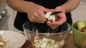 Cutting apple wedges into bowl preparing homemade compote. Slicing fresh fruit adding pieces for traditional drink. Chopping ripe apple filling container with base for sweet homemade beverage - Powered by Shutterstock - Get 15% off with code: PIKWIZARD15