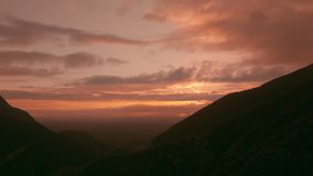 Cinematic aerial dolly-in revealing glowing orange sunrise emerging from behind dark silhouette of Sierra Madre mountains at Presa de la Boca in Santiago, Nuevo León. - Powered by Shutterstock - Get 15% off with code: PIKWIZARD15