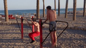 Two athletic men training together at a beach workout park. Shirtless athletes performing impressive synchronized calisthenics exercises - Powered by Shutterstock - Get 15% off with code: PIKWIZARD15