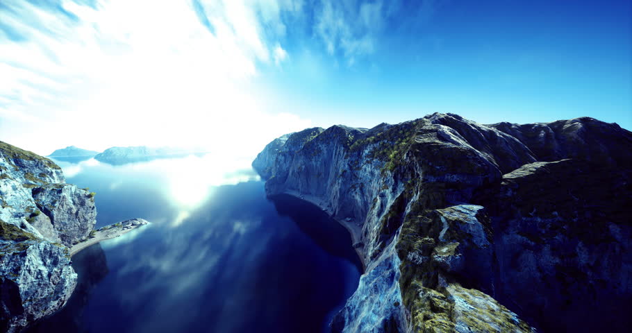 Cliffs rise dramatically on either side of calm water, capturing the brilliant sunlight against a clear blue sky. The tranquil scene showcases natures beauty and serenity.