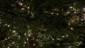 Macro view of an outdoor artificial Christmas tree with twinkling lights, capturing festive garlands, vibrant ornaments and a cozy holiday atmosphere at night - Powered by Shutterstock - Get 15% off with code: PIKWIZARD15