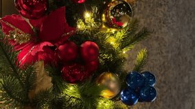 Macro view of gold, red, and blue Christmas baubles and poinsettia leaves on an outdoor holiday display, with twinkling garlands creating a festive and vibrant atmosphere - Powered by Shutterstock - Get 15% off with code: PIKWIZARD15