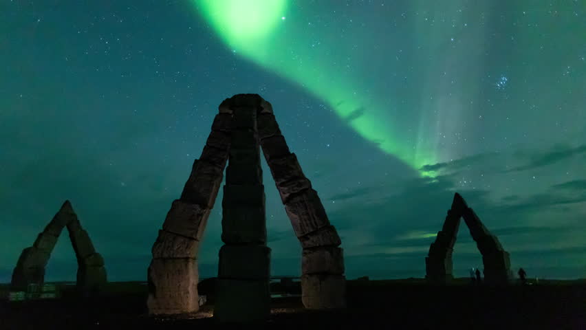 Aurora borealis glowing green over the iconic landmark Arctic Henge, in north east Iceland. Time lapse.