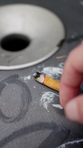 man flicking cigarette stub onto fabric surface, littering scene showing neglected public space and pollution, vivid depiction of cigarette disposal causing environmental damage and urban neglect
