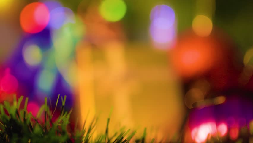 Color bright image of festive attributes beauteous box with a gift next to New Year tinsel and light of garlands. Holidays concept. Selective focus.