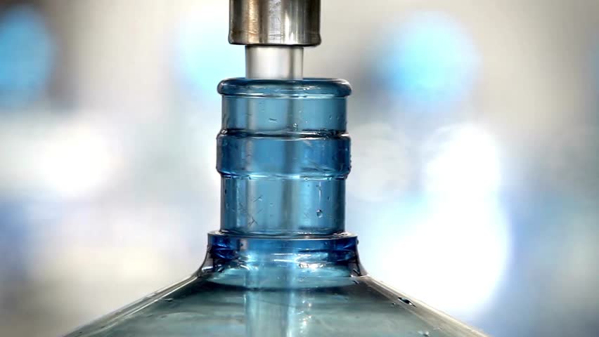Water factory bottling filling pure spring water into bottles. bottle neck focus closeup