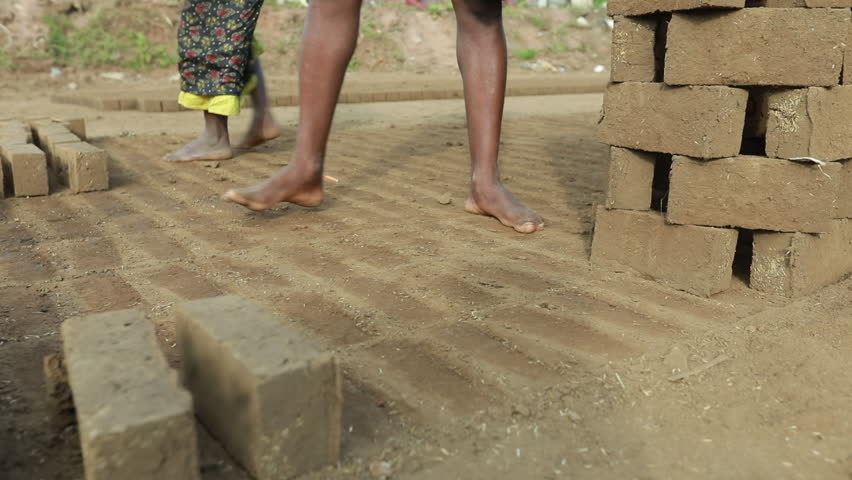Close-up of construction workers laying bricks outdoors, showing laborers building a wall in sunlight with detailed manual work.