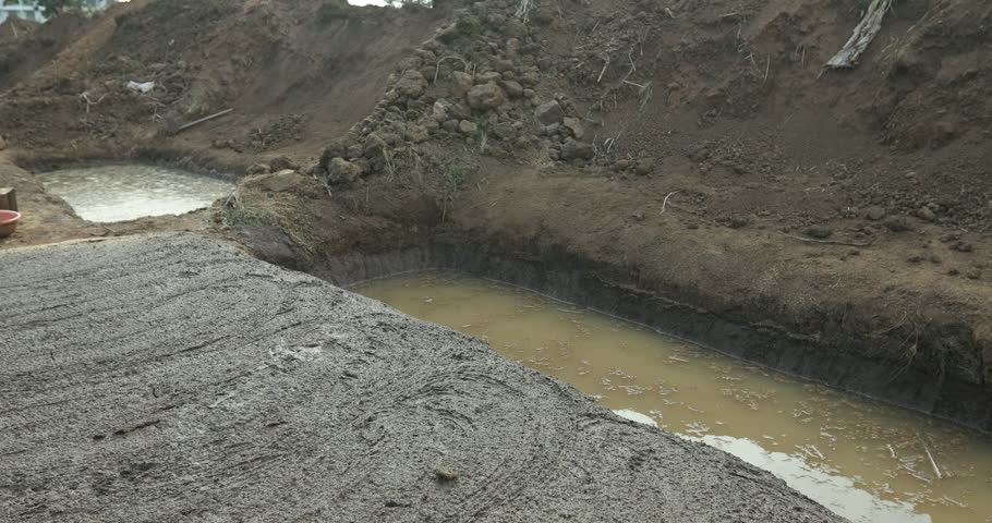 Close-up of construction workers laying bricks outdoors, showing laborers building a wall in sunlight with detailed manual work and teamwork.