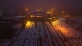 Railway bridge at night illuminated by lights in fog above snowy tracks captured from a drone during a smooth overhead flight - Powered by Shutterstock - Get 15% off with code: PIKWIZARD15