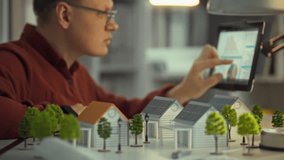 An engineer is examining data on a touchpad while surrounded by miniature houses equipped with solar panels. This activity focuses on promoting renewable energy solutions - Powered by Shutterstock - Get 15% off with code: PIKWIZARD15