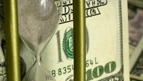 Sand dropping through the bulb of the hourglass and money on the background. Hourglass with sand stand among money. Deadline, business planning, finance and time is money concept. - Powered by Shutterstock - Get 15% off with code: PIKWIZARD15