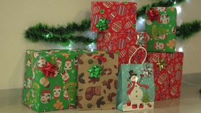 A festive arrangement of Christmas gift boxes wrapped in colorful holiday-themed paper featuring Santa Claus, snowmen, ornaments, and decorative bows. The presents are neatly stacked with a green garl - Powered by Shutterstock - Get 15% off with code: PIKWIZARD15