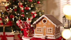 Beautiful gingerbread house and cup with candy canes on table against flashing blurred lights indoors, closeup with space for text. Christmas atmosphere - Powered by Shutterstock - Get 15% off with code: PIKWIZARD15