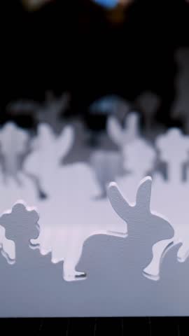 Easter fair. close-up. decorative white figurines of Easter bunnies in the grass, made of plywood, are on a display in a store. traditional european easter decor and decorations.