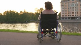 Sad senior woman sitting in wheelchair walking on road in city outdoor, back view. Old paralyzed lady in chair for people with disability feel depressed. Lonely elderly sick woman sits on wheelchair - Powered by Shutterstock - Get 15% off with code: PIKWIZARD15