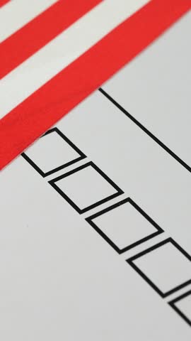 Voter marks box next to candidate with red marker on ballot. Democratic elections in USA. National flag with stars in background. Electoral process ensures fair political participation through voting