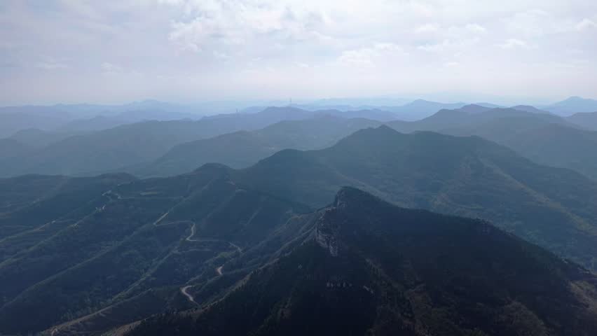 Aerial view of autumn scenery: layered forests and overlapping mountain ranges