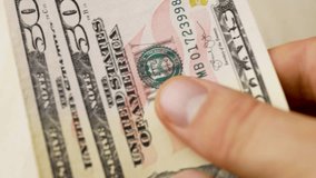Person counting 50 dollar bills. Circulating currency used for household expenses, supporting daily necessities, budget allocations, and structured personal financial management - Powered by Shutterstock - Get 15% off with code: PIKWIZARD15