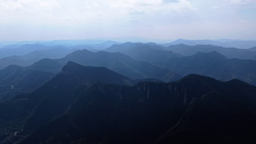 Aerial view of autumn scenery: layered forests and overlapping mountain ranges