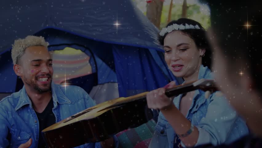 Woman reaching guitar lifting neck offering guitar tapping for music at camp sparkles overlay. Acoustic, instrument, campsite, friends, outdoor, forest, casual