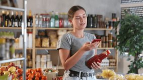 Young woman buyer scanning qr code for fresh tomato juice in bottle in grocery store - Powered by Shutterstock - Get 15% off with code: PIKWIZARD15