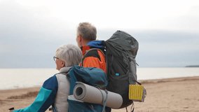Hiking tourism adventure. Senior couple man woman enjoying outdoor recreation hiking on beach. Happy old people backpackers hikers enjoy walking hike trekking tourism active vacation beauty of nature - Powered by Shutterstock - Get 15% off with code: PIKWIZARD15