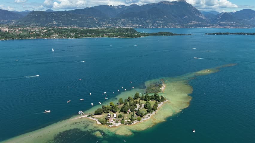 Summer travel Italy: Aerial drone footage of Isola di San Biagio on Lake Garda with turquoise water.