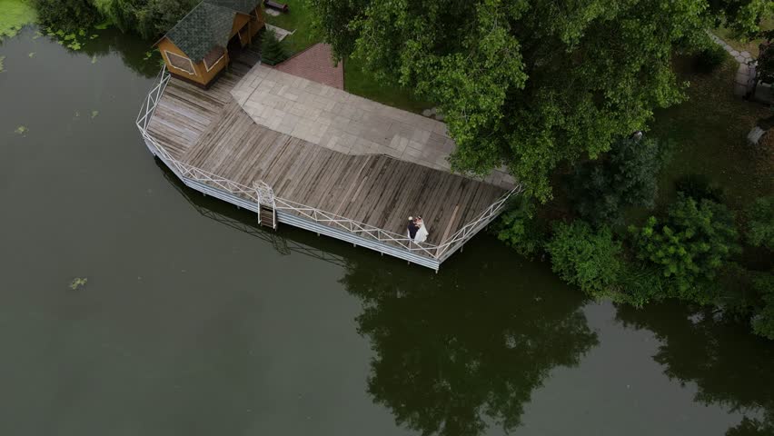 A couple standing on a dock in the middle of a lake
