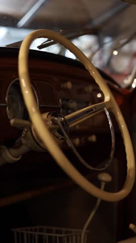 Close-up of a vintage car steering wheel and dashboard, showcasing classic automotive design, nostalgic craftsmanship, and retro interior aesthetics.