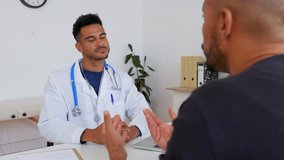 Young male doctor talking with patient at medical consultation. Professional explaining medical information clearly. Healthcare and communication concept.  - Powered by Shutterstock - Get 15% off with code: PIKWIZARD15