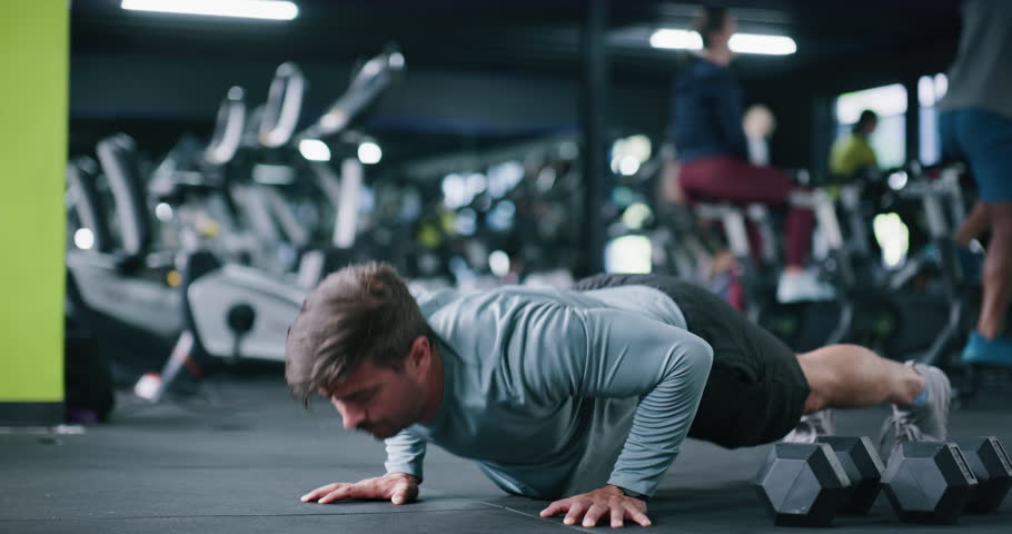 Man, fitness and gym with push ups for chest workout, arm exercise or lifting body weight. Active, male person or training on floor with core strength for muscle gain or wellness in health club