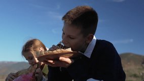Children, eating, picnic. Two hungry siblings enjoy baked flatbread or pie during a sunny outdoor lunch break in the mountains. - Powered by Shutterstock - Get 15% off with code: PIKWIZARD15