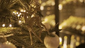 A detailed 4K view of a Christmas tree with warm, twinkling lights and gold ornaments, featuring a prominent glittery reindeer. - Powered by Shutterstock - Get 15% off with code: PIKWIZARD15