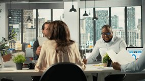 Diverse coworkers engaged in consulting and report sharing at office. Professional team reviews visual data and documents to enhance business strategy and performance goals. Camera B. - Powered by Shutterstock - Get 15% off with code: PIKWIZARD15