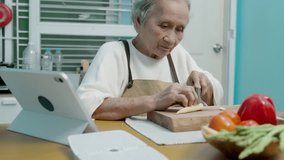 Senior woman preparing vegetable to make salad in the kitchen using a digital tablet to learn - Powered by Shutterstock - Get 15% off with code: PIKWIZARD15