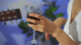 Woman savors tranquil wine moment, Intimate scene of woman with glass of red wine and acoustic tunes, Gentle evening scene featuring woman enjoying peaceful night with wine and acoustic melodies - Powered by Shutterstock - Get 15% off with code: PIKWIZARD15